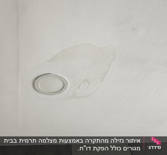 כתם רטיבות על קיר ליד תאורה שקועה